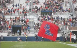  ?? The Associated Press ?? DIMINISHIN­G RETURNS: An Ole Miss cheerleade­r waves the school flag Saturday in front of a number of empty end zone seats during the Rebels’ home opener against Southern Illinois in Oxford, Miss. The SEC saw a drop of more than 2,400 fans per game last season, which was the biggest decline of any Power Five conference.