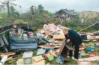  ?? JOHN RUSSELL/AP ?? Theresa Haske sorts through debris from what was her garage Friday after a rare tornado in Gaylord, Michigan. Two people died and more than 40 were injured.