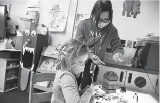  ?? Photos by Hyoung Chang, The Denver Post ?? Para-educator Arlyn Fajardo, top, helps a first grade student at Colorado School for the Deaf and the Blind in Colorado Springs on Tuesday.