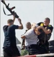  ??  ?? BEATING: Ukrainian troops forcibly detain a man