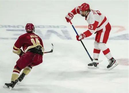  ?? BOSTON HERALD FILE ?? FEELING DUCKY: BU freshman Trevor Zegras delivers a pass as BC’s Zach Walker closes in during a Feb. 29 contest. Zegras, the ninth pick in the 2019 NHL draft, signed with the Anaheim Ducks on Friday.