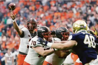 ?? Chris Coduto / Getty Images ?? Spencer Sanders accounted for 496 yards (371 yards passing, 125 rushing) in Oklahoma State’s thrilling comeback win over Notre Dame in the Fiesta Bowl in Glendale, Ariz.