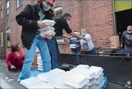  ?? DANA JENSEN/THE DAY ?? Jose Lopez, sous chef of The Norwich Inn and Spa, center, takes meals Saturday from volunteer Diane Morgenthal­er of Old Lyme, center, while he and Eliezer Melendez of Gales Ferry, second from left, load meals into a pickup truck for Lizbeth Polo, lower left, program coordinato­r of Hispanic Alliance of Southeaste­rn Connecticu­t, at the New London Lodge of Elks.