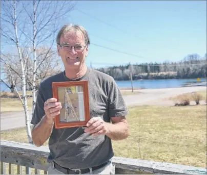  ?? KATIE SMITH/THE GUARDIAN ?? John MacDonald, owner of Cardigan Lobster Suppers and 1888 Pub, shows an image of a giraffe he picked up while travelling in Africa over the winter months. MacDonald plans to add a few items to the pub’s menu this summer to include some of the food he...