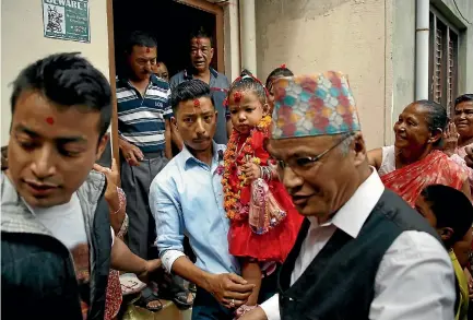  ?? PHOTO: REUTERS ?? The newly appointed Kumari of Kathmandu, Trishna Shakya, 3, is carried by her father as they leave their home in the Nepalese capital for a palace where she will live and be waited on until she reaches puberty.