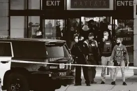  ?? Nam Y. Huh / Associated Press ?? FBI and police coordinate outside the Mayfair Mall after a gunman wounded seven adults and a teenager Friday afternoon inWauwatos­a, Wis.