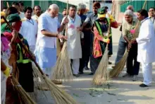  ?? — AFP ?? Prime Minister Narendra Modi (left) sweeps a street in a residentia­l colony in New Delhi
