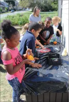  ?? MICHILEA PATTERSON — FOR DIGITAL FIRST MEDIA ?? A group of students does a pumpkin craft at the Barth Elementary School community garden in Pottstown.