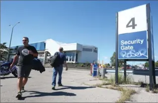  ?? VINCE TALOTTA, TORONTO STAR ?? GM workers do a shift change at an Oshawa car assembly plant Monday, which got a new lease on life beyond 2019.