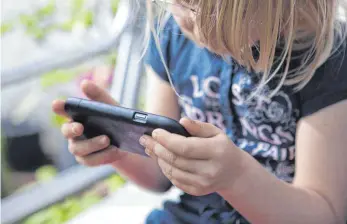  ?? FOTO: DPA ?? Smartphone­s sind auch für Kinder ungemein verführeri­sch und anziehend.