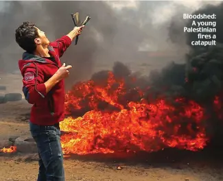  ??  ?? Bloodshed: A young Palestinia­n fires a catapult