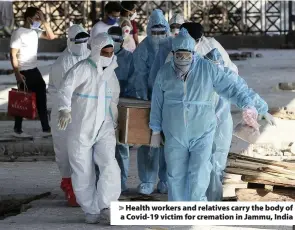  ??  ?? > Health workers and relatives carry the body of a Covid-19 victim for cremation in Jammu, India