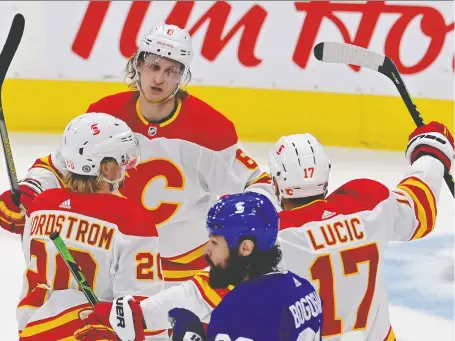  ?? FRANK GUNN/THE CANADIAN PRESS ?? Calgary Flames blueliner Juuso Valimaki, centre, celebrates his goal against the Toronto Maple Leafs on Tuesday.