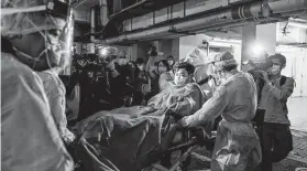  ?? New York Times file photo ?? Paramedics transport a patient believed to be Hong Kong’s first coronaviru­s patient to a hospital on Jan. 22, 2020.