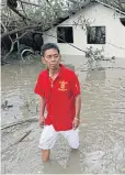  ??  ?? A resident wades through flooding in the typhoon-hit town of Milaor.