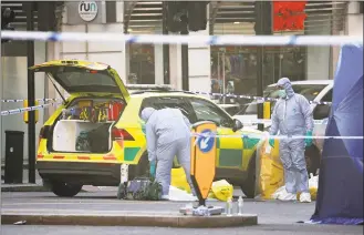  ?? Steve Parsons / Associated Press ?? Forensic officers attend the scene in central London on Saturday after an attack on London Bridge on Friday. UK counterter­rorism police on Saturday searched for clues into how a man imprisoned for terrorism offenses before his release last year managed to stab several people before being tackled by bystanders and shot dead by officers on London Bridge. Two people were killed and three wounded.