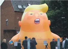  ?? AFP ?? Activists inflate a giant balloon depicting US President Donald Trump as an orange baby in north London on Tuesday