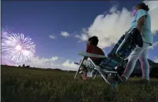  ?? JONAH HINEBAUGH/TAMPA BAY TIMES VIA AP ?? Javonnie Jackson, 9, left, sits with his grandmothe­r
Zoraida Rullan, 69, watching fireworks explode over Nathan Benderson Park on Friday, July 3, in Sarasota, Fl. The pair were reunited after nearly five months of separation due to the coronaviru­s.