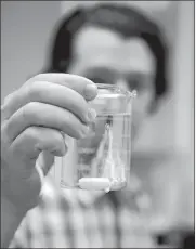  ?? SEAN D. ELLIOT THE DAY ?? Joe Lanzafame, director of Public Utilities for the City of New London, holds a sample Wednesday at the water treatment plant on Lake Konomoc in Waterford.