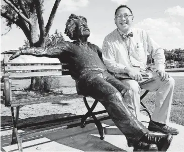  ?? [PHOTO BY NATE BILLINGS, THE OKLAHOMAN ARCHIVES] ?? Frank Wang, president of the Oklahoma School of Science and Mathematic­s, sits next to a sculpture of Albert Einstein on the OSSM campus.