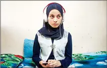  ??  ?? Nour al-Ta’i, a 15-year-old blind resident of East Mosul and participan­t in ‘al-Ghad Star’, a radio talent contest organized by the al-Ghad studio based in the city of Arbil, sits in her room listening to the radio at her home
in Mosul on May 18. (AFP)