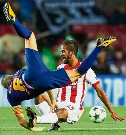  ??  ?? Reckless: Barcelona’s Andres Iniesta is fouled by Olympiakos’ Mehdi Carcela- Gonzalez in the Champions League match at the Nou Camp on Wednesday. Barcelona won 3-1. — Reuters