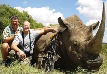  ??  ?? Pitiless poachers: Palmer (right) and a fellow hunter with a slaughtere­d rhino