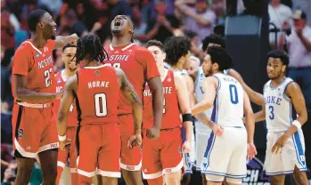  ?? CARMEN MANDATO/GETTY ?? North Carolina State’s DJ Burns Jr. shouts as he celebrates with teammates after scoring and drawing a foul against Duke in the South Region final of the NCAA Tournament on Sunday in Dallas. The ACC has had six different schools reach the Final Four since 2015.