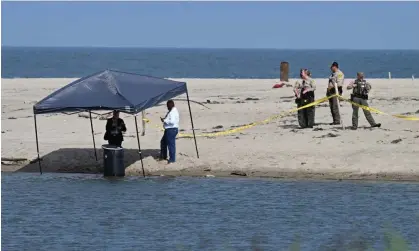  ?? Photograph: Robyn Beck/AFP/Getty Images ?? Officials stand next to a barrel where a body was discovered in Malibu Lagoon state beach, California.