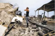  ?? JAE C. HONG/ASSOCIATED PRESS ?? Amy Nelson, 30, breaks down as she goes through the remains of her home devastated by a wildfire June 25 in South Lake. “I didn't think it was going to be this bad,” said Nelson.