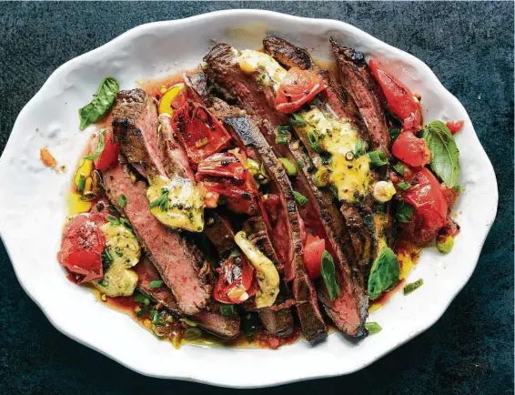  ?? Photos by David Malosh / New York Times ?? What flank steak lacks in softness, it makes up for with a deeply mineral brawniness that can stand up to the spiciest, tangiest, most pungent marinades. This steak is topped with a Worcesters­hire butter and charred ripe tomatoes.