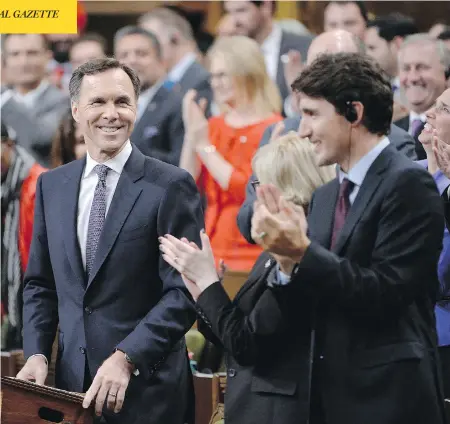 ?? ADRIAN WYLD / THE CANADIAN PRESS ?? Liberals cheer Finance Minister Bill Morneau after he delivered an economic statement Tuesday that shows an expected $8.9 billion revenue bump.