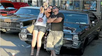  ??  ?? Michael and Szetlana Grills take a selfie in front of their ‘67 Pontiac classic car during an event in Chicago.