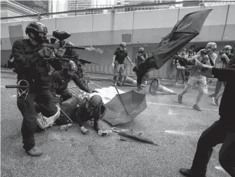  ?? REUTERS ?? A riot police officer fires pepper-spray projectile toward anti-government protesters demonstrat­ing near the Legislativ­e Council building in Hong Kong late last month.