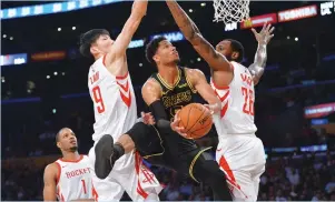  ?? (Reuters) ?? LOS ANGELES LAKERS guard Josh Hart goes under Houston Rockets defenders Zhou Qi and Tarik Black (right) for two of his team-high 20 points on Tuesday night in a game the visiting Rockets won 105-99.