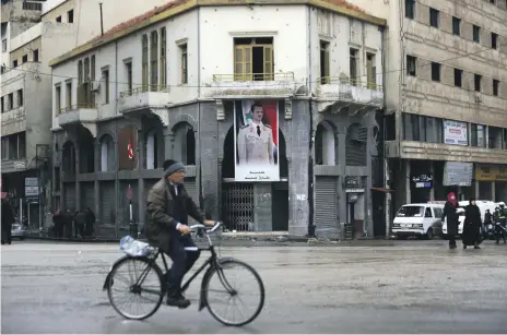  ?? AP ?? A portrait of Syrian President Bashar Al Assad hangs in a clock square in the old city of Homs