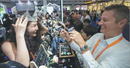  ?? YUAN CHEN / FOR CHINA DAILY ?? A customer tries on a crown designed for a beauty pageant at the Czech booth on Saturday during the Fourth China Internatio­nal Consumer Products Expo in Haikou, Hainan province. The expo is scheduled to run through Thursday.