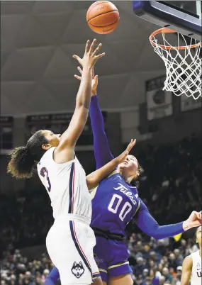  ?? Stephen Dunn / Associated Press ?? UConn’s Megan Walker (3) goes up against Tulsa’s Kendrian Elliott (00) during the first half on Sunday.