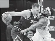  ?? Jim Mone / Associated Press ?? Denver’s Nikola Jokic, left, scored 20 points, including a jumper to send the game into overtime, as the Nuggets won their fourth straight contest.