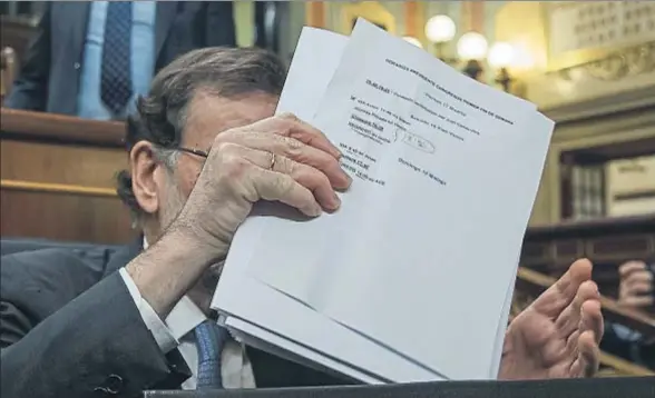  ?? DANI DUCH ?? La agenda privada. Mariano Rajoy dejó ayer al descubiert­o, al guardar unos papeles en su cartera, la agenda que tiene prevista para este fin de semana y que incluye una “comida privada” en Vitoria: comerá con Alfonso Alonso y Javier Maroto