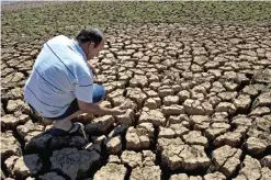  ??  ?? VARGEM: A man checks cracked ground in an area which used to be underwater at the Jaguari dam, in Vargem, 100km from Sao Paulo, during a drought affecting Sao Paulo state, Brazil. — AFP