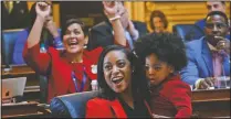  ?? (File Photo/AP/Steve Helber) ?? Virginia Delegate Jennifer Carroll Foy holds her son, Alex Foy, as she and Delegate Hala Ayala (back), D-Prince William, celebrate on Jan. 27 the passage of the Equal Rights Amendment in the House chambers at the Capitol in Richmond, Va.