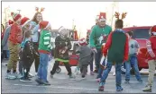  ??  ?? The sunset illumined the western sky as participan­ts lined up for the annual Christmas parade beginning about 4:30 p.m. Saturday. Children played while waiting for the parade to begin and while adults finished last-minute preparatio­ns on the floats.