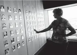  ?? ALGERINA PERNA / BALTIMORE SUN ?? A woman stands by the 9/11 memorial exhibit on the top floor of the Baltimore’s World Trade Center in this 2012 photo. The photograph­s are of Marylander­s killed in the 9/11 attacks.