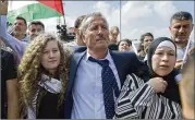  ?? NASSER NASSER / THE ASSOCIATED PRESS ?? Palestinia­n Bassem Tamimi supports daughter Ahed (left) and wife Nariman as they arrive at their West Bank village of Nebi Saleh.