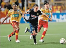  ??  ?? Paul Aguilar trata de superar a dos jugadores del Herediano