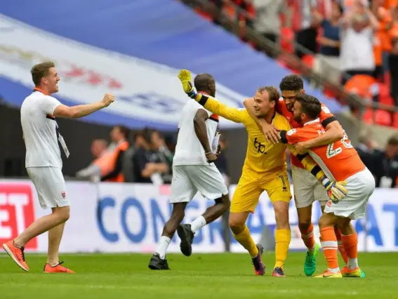  ??  ?? Blackpool’s players celebrate securing their return to League One (Getty)