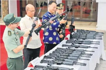  ?? — Reuters photo ?? Philippine Defence Secretary Delfin Lorenzana (second left), with H.E. Zhao Jianhua (second right), ambassador of People’s Republic of China to the Philippine­s and Ano (right), inspects automatic rifles during the turnover ceremony of China’s urgent...