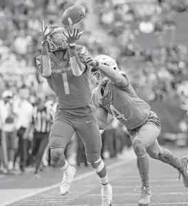  ?? John Locher / Associated Press ?? Boise State wide receiver Cedrick Wilson catches a pass over Oregon cornerback Thomas Graham Jr. during the second half of the Las Vegas Bowl on Saturday.