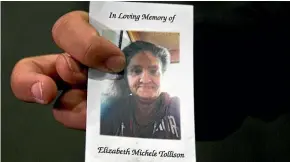  ??  ?? Nick Ramirez, holds a memorial card of Elizabeth Tollison, who was fatally shot by Los Angeles police officers during a hostage situation.